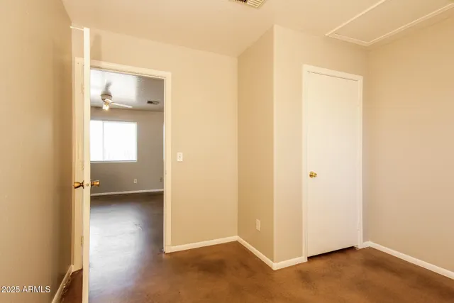 an empty room with a window and a ceiling fan