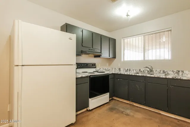 a kitchen with granite countertop a refrigerator and a sink