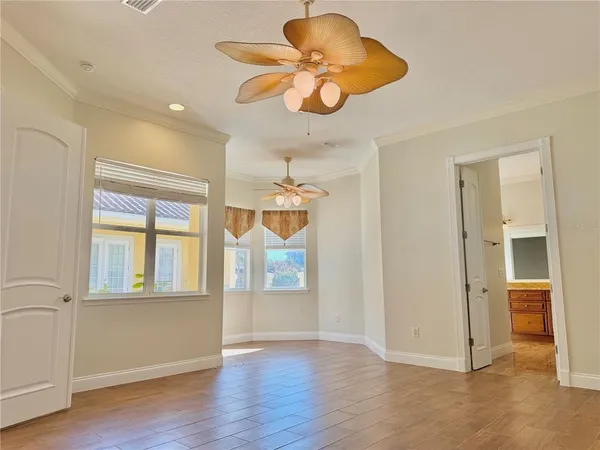 an empty room with wooden floor and windows
