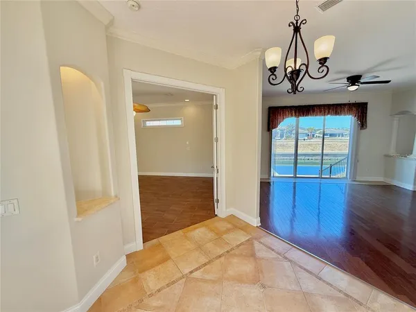 a view of an empty room with window and wooden floor