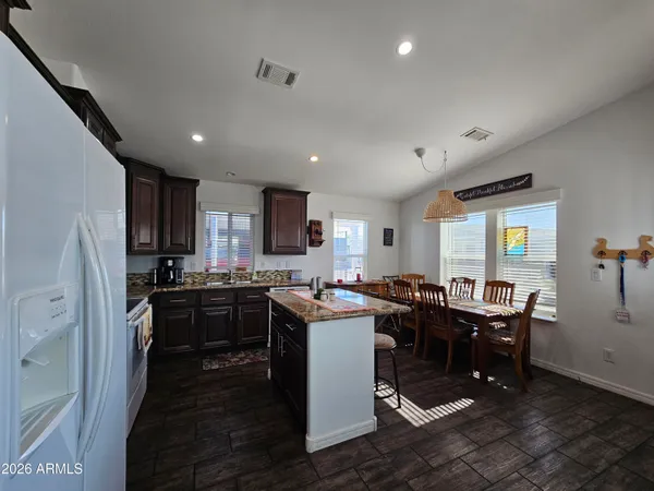 a kitchen with kitchen island granite countertop lots of counter top space and stainless steel appliances