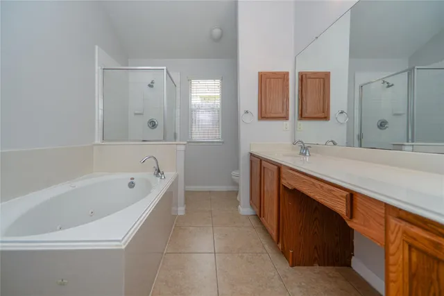 a spacious bathroom with a bathtub sink and mirror