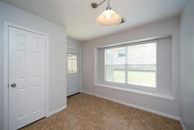 a view of an empty room with a window and closet area