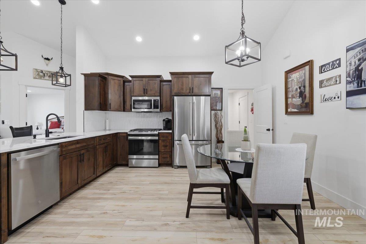 918 Sierra Street Vale, OR 97918 - Photo 16 of 42 Kitchen featuring wood-finish flooring, stainless steel appliances, dark wood cabinetry, white countertops, and recessed lighting