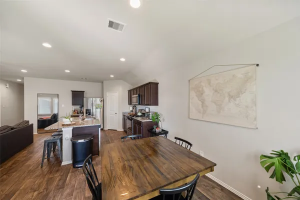 a kitchen with granite countertop a sink a counter top space stove and cabinets