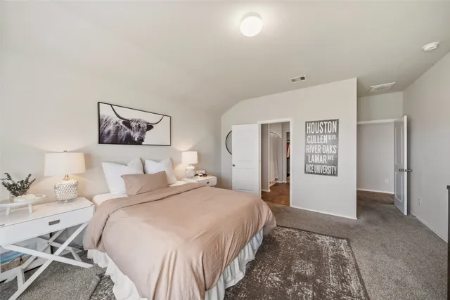 a bedroom with a large bed and painting on the wall