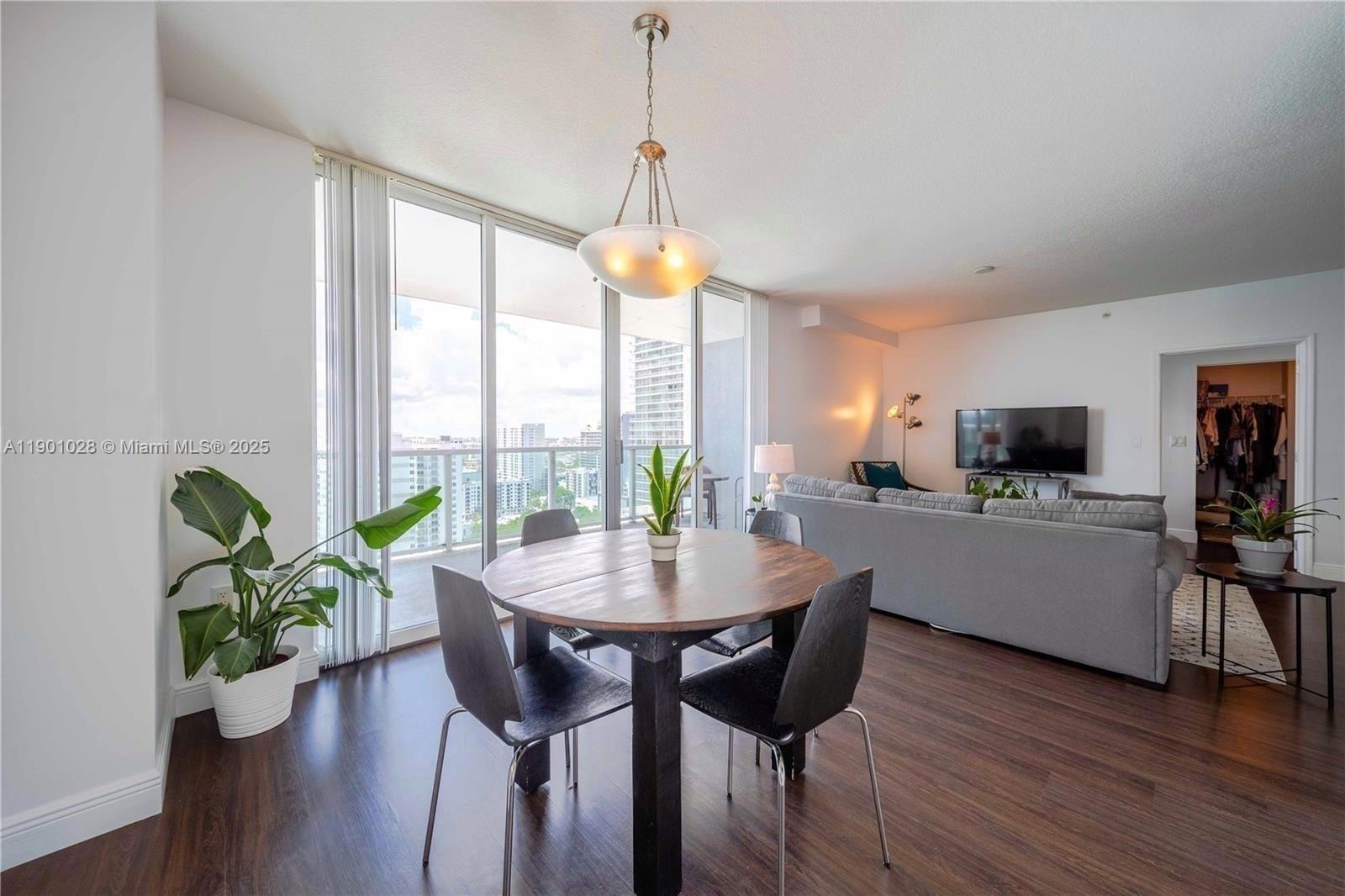a dining room with furniture window and wooden floor