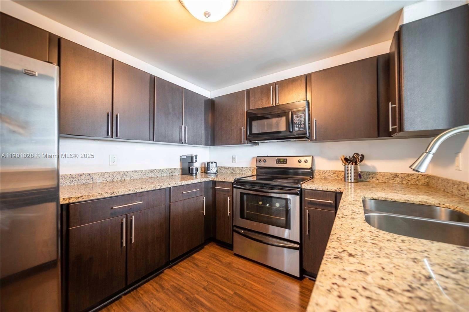 1250 South Miami Avenue, Unit 2201 Miami, FL 33130 - Photo 11 of 30 a kitchen with stainless steel appliances granite countertop a stove a sink and a microwave