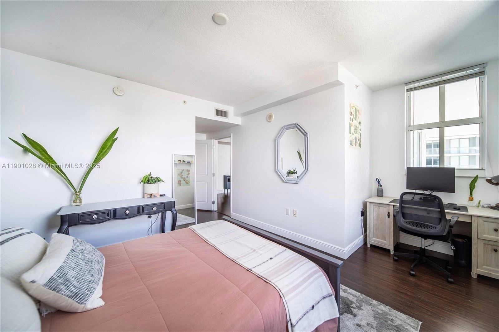 1250 South Miami Avenue, Unit 2201 Miami, FL 33130 - Photo 13 of 30 a bedroom with a bed a couch and dresser with wooden floor