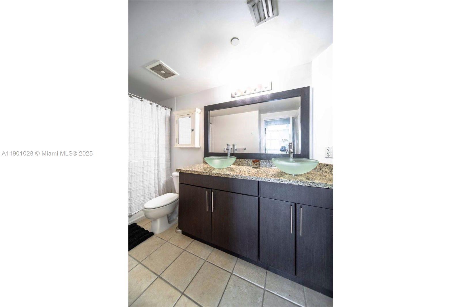 1250 South Miami Avenue, Unit 2201 Miami, FL 33130 - Photo 17 of 30 a bathroom with a granite countertop sink and a mirror