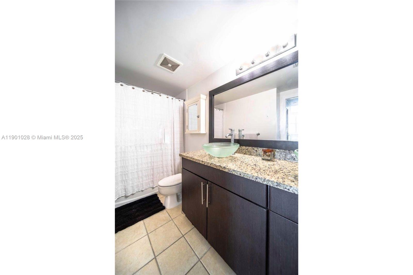 1250 South Miami Avenue, Unit 2201 Miami, FL 33130 - Photo 28 of 30 a bathroom with a granite countertop sink and a mirror