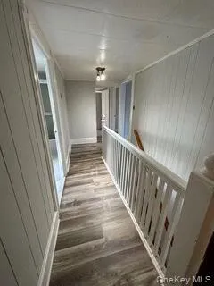 a view of staircase with lots of frames on wall and wooden floor