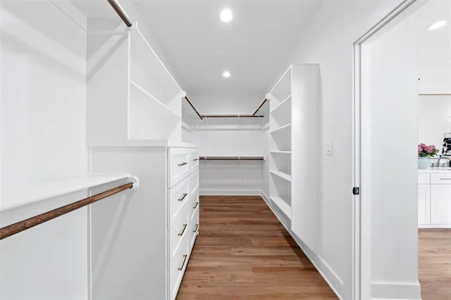 a hallway with white cabinets and wooden floor