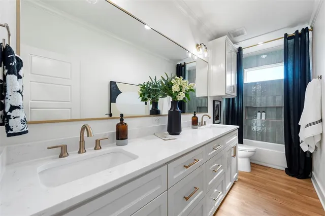 a bathroom with a double vanity sink toilet and shower