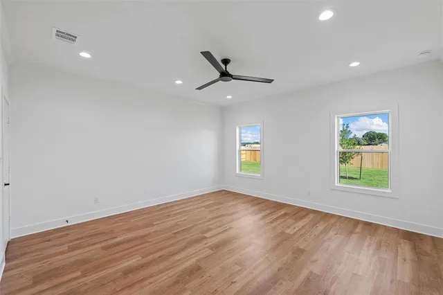 an empty room with a window and a ceiling fan