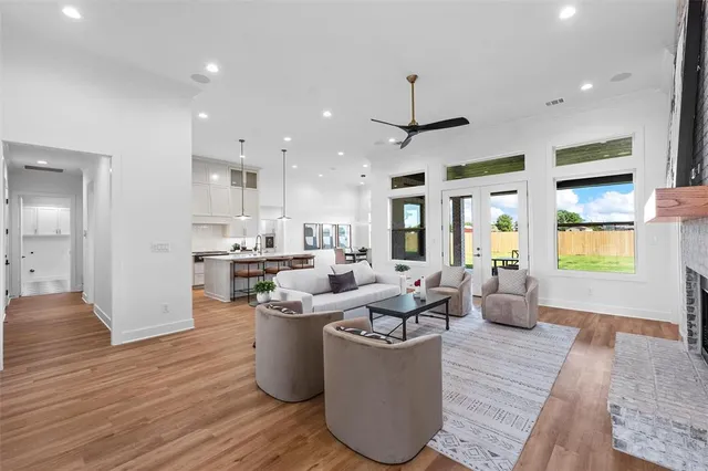 a living room with furniture kitchen and a large window