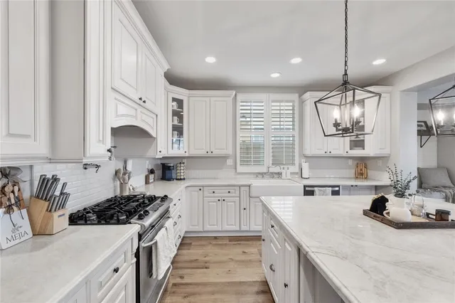 a kitchen with stainless steel appliances granite countertop a sink stove and cabinets