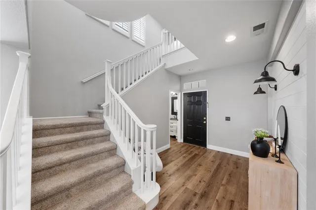 a view of hallway with wooden floor and stairs