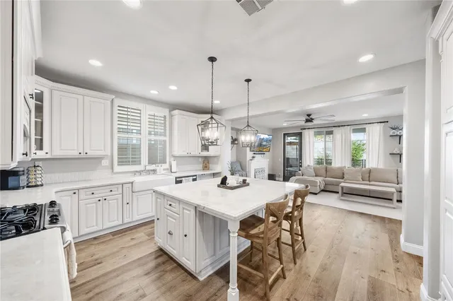 a kitchen with a refrigerator a sink and wooden floor
