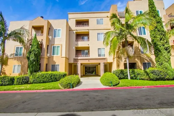 a front view of multi story residential apartment building with yard and green space