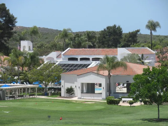 a living room with furniture a chandelier and wooden floor