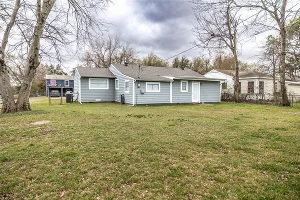 a view of a house with a big yard and large trees