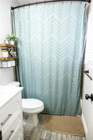 a bathroom with a toilet and a shower curtain