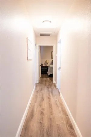a view of a hallway with wooden floor