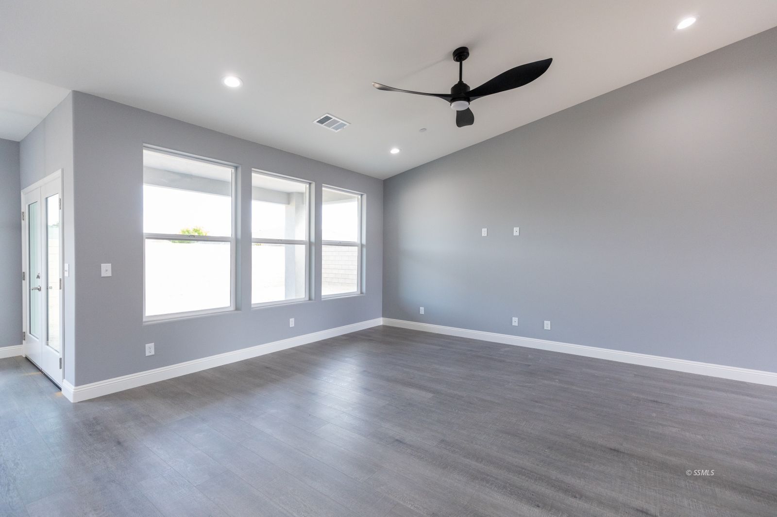 424 Thomas Street Ridgecrest, CA 93555 - Photo 6 of 30 an empty room with wooden floor and windows