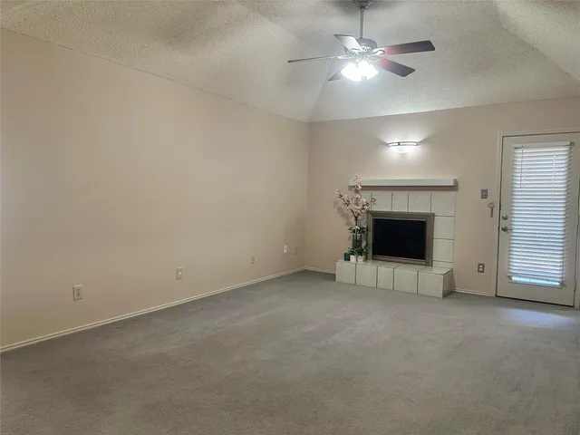 an empty room with fireplace and fan