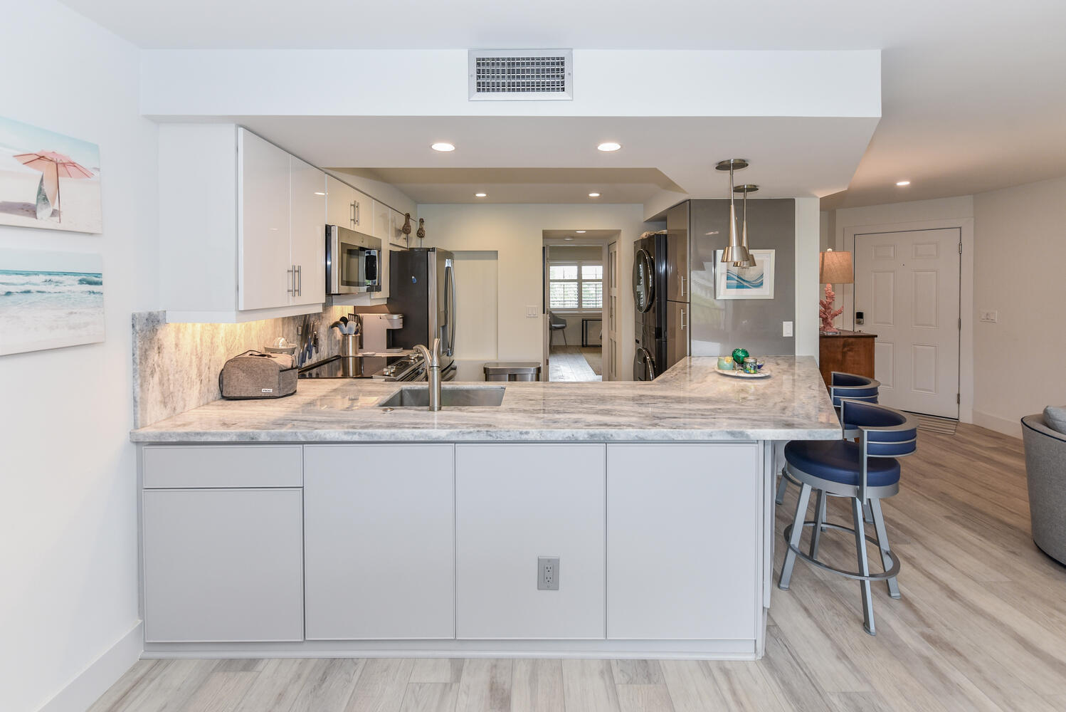 1605 Highway 1, Unit B302 Jupiter, FL 33477 - Photo 19 of 47 a kitchen with granite countertop a sink and chairs