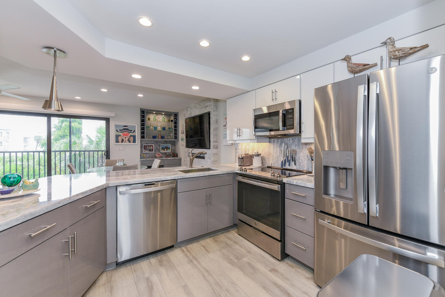 1605 Highway 1, Unit B302 Jupiter, FL 33477 - Photo 24 of 47 a kitchen with stainless steel appliances granite countertop a refrigerator a stove a sink and a microwave