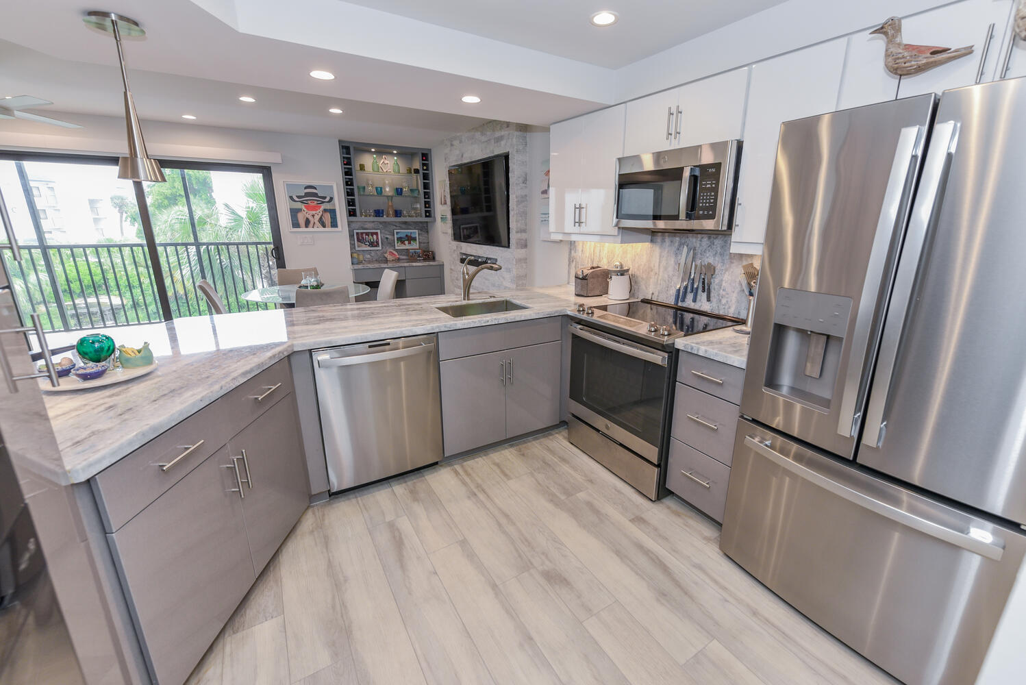 1605 Highway 1, Unit B302 Jupiter, FL 33477 - Photo 25 of 47 a kitchen with stainless steel appliances granite countertop a refrigerator a sink a stove top oven a refrigerator with wooden floors