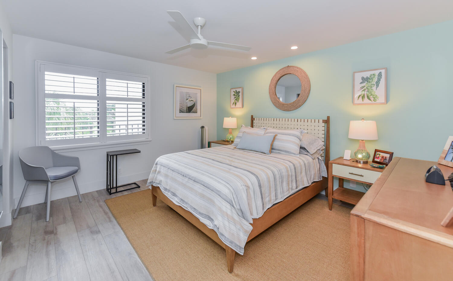 1605 Highway 1, Unit B302 Jupiter, FL 33477 - Photo 32 of 47 a bedroom with a bed and a lamp on dresser with wooden floor