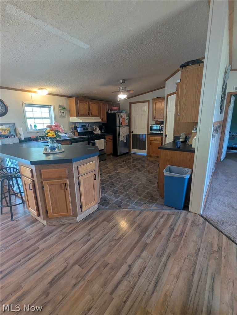 17960 Raven Road Salesville, OH 43778 - Photo 11 of 27 Kitchen featuring a central island with wood cabinetry, wood-finish flooring, and a ceiling fan