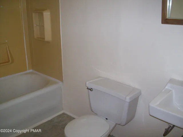 a white toilet sitting next to a bath tub
