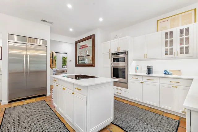 a kitchen with stainless steel appliances granite countertop a refrigerator and a stove top oven