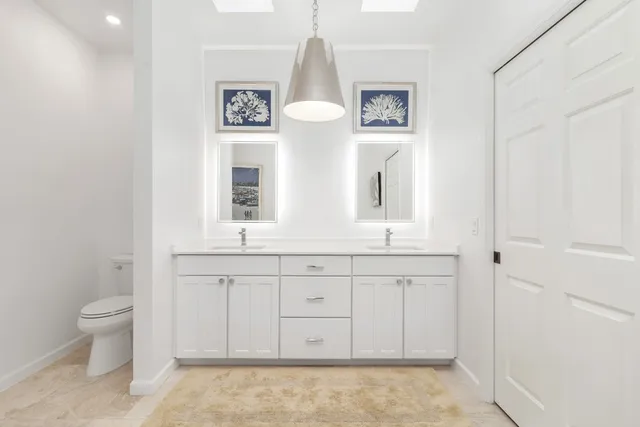 a bathroom with a toilet sink and mirror