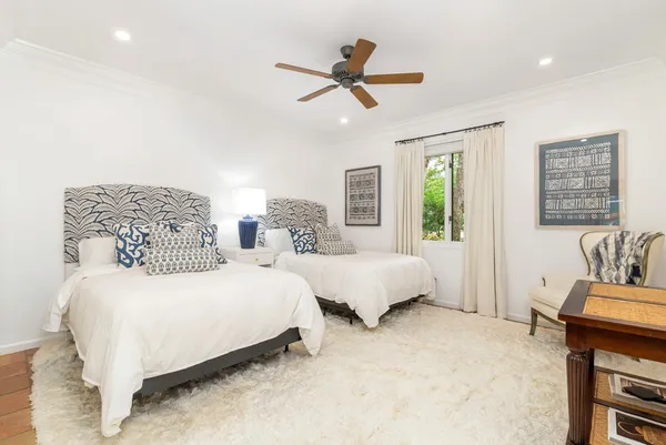 a bedroom with two beds and painting on the wall