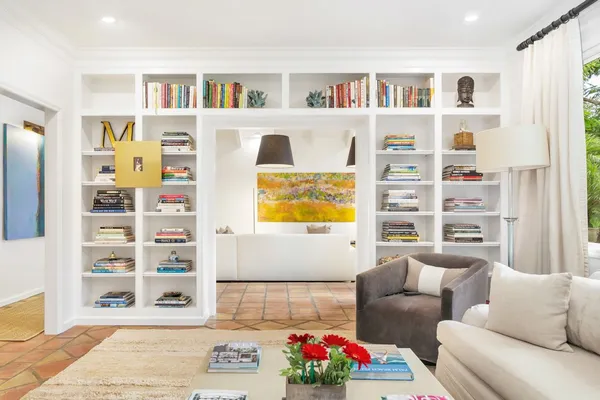 a living room with furniture a rug and white walls