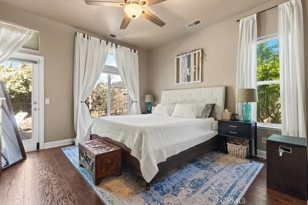 a bed sitting in a spacious bedroom next to a window