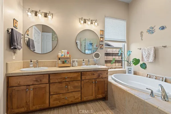 a bathroom with a granite countertop double vanity sink and a mirror