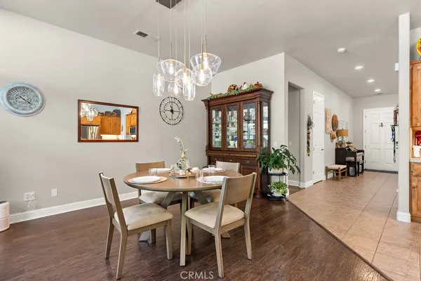a view of a dining room with furniture a chandelier and wooden floor