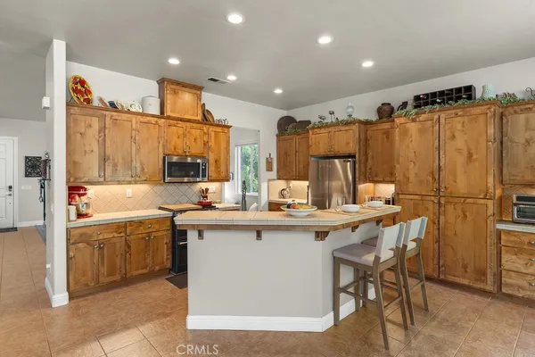 a kitchen with stainless steel appliances granite countertop a sink and a refrigerator