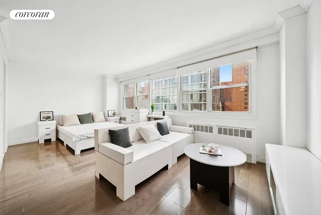 a living room with furniture large window and wooden floor