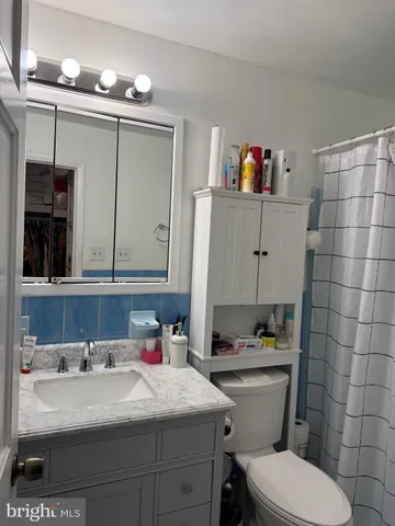 a bathroom with a sink vanity mirror and toilet