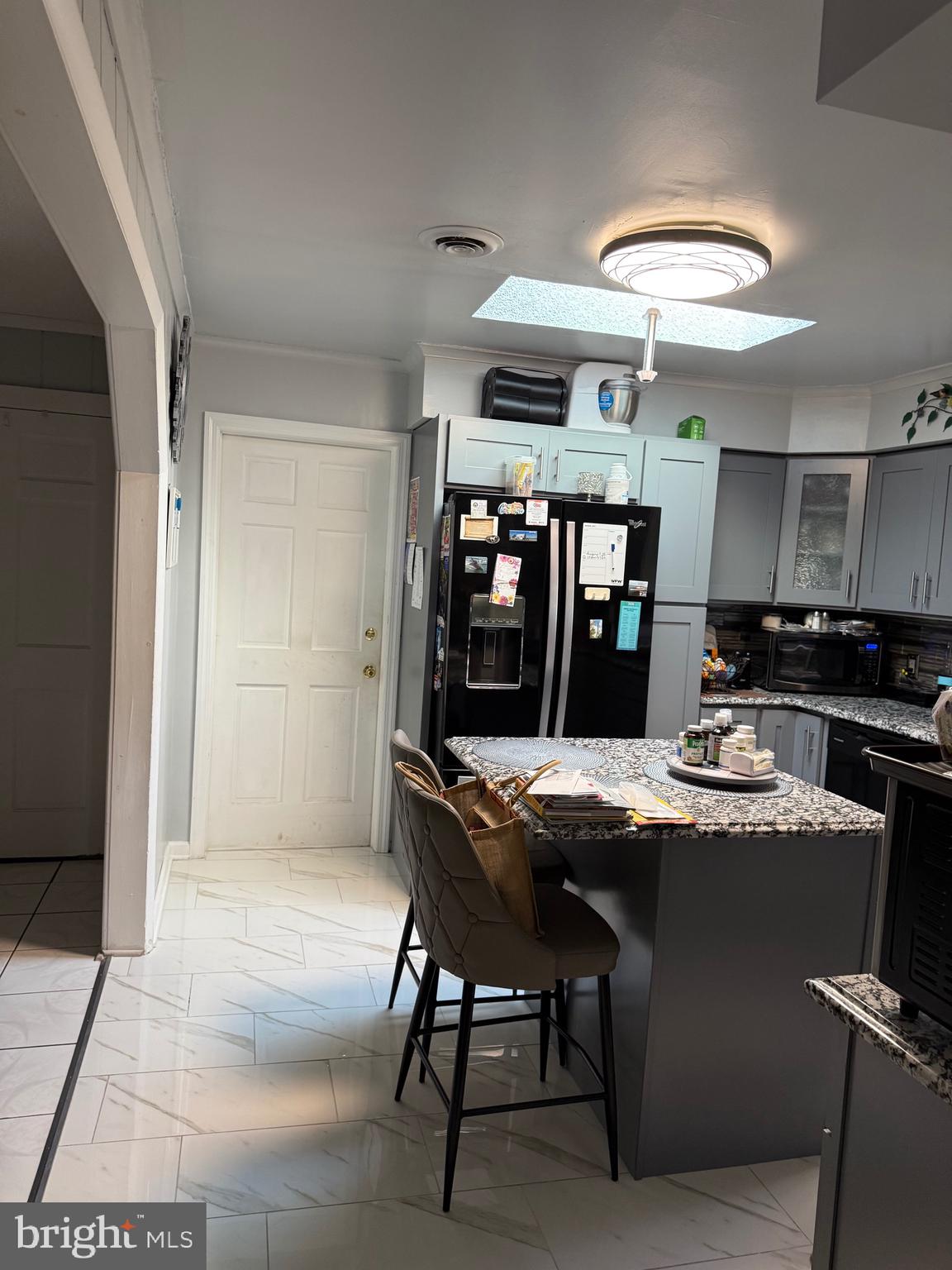 1339 Monmouth Road Mount Holly, NJ 08060 - Photo 20 of 34 a dining room with stainless steel appliances kitchen island granite countertop a table chairs and a refrigerator
