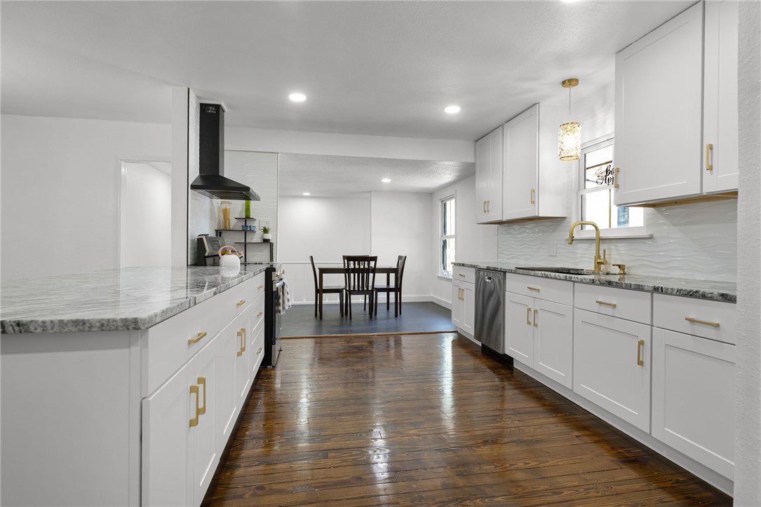 1012 East Main Street Sinton, TX 78387 - Photo 11 of 34 a large kitchen with stainless steel appliances granite countertop a lot of counter space and wooden floors