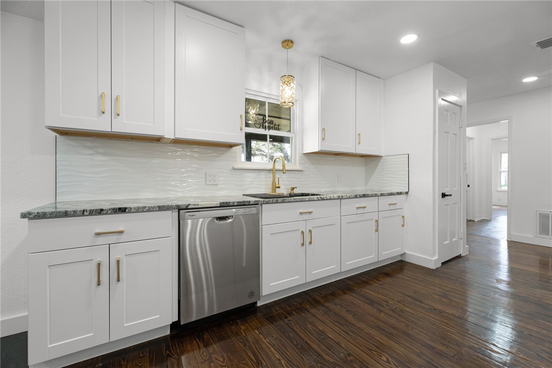 1012 East Main Street Sinton, TX 78387 - Photo 13 of 34 a kitchen with stainless steel appliances granite countertop white cabinets granite counter tops and a wooden floors