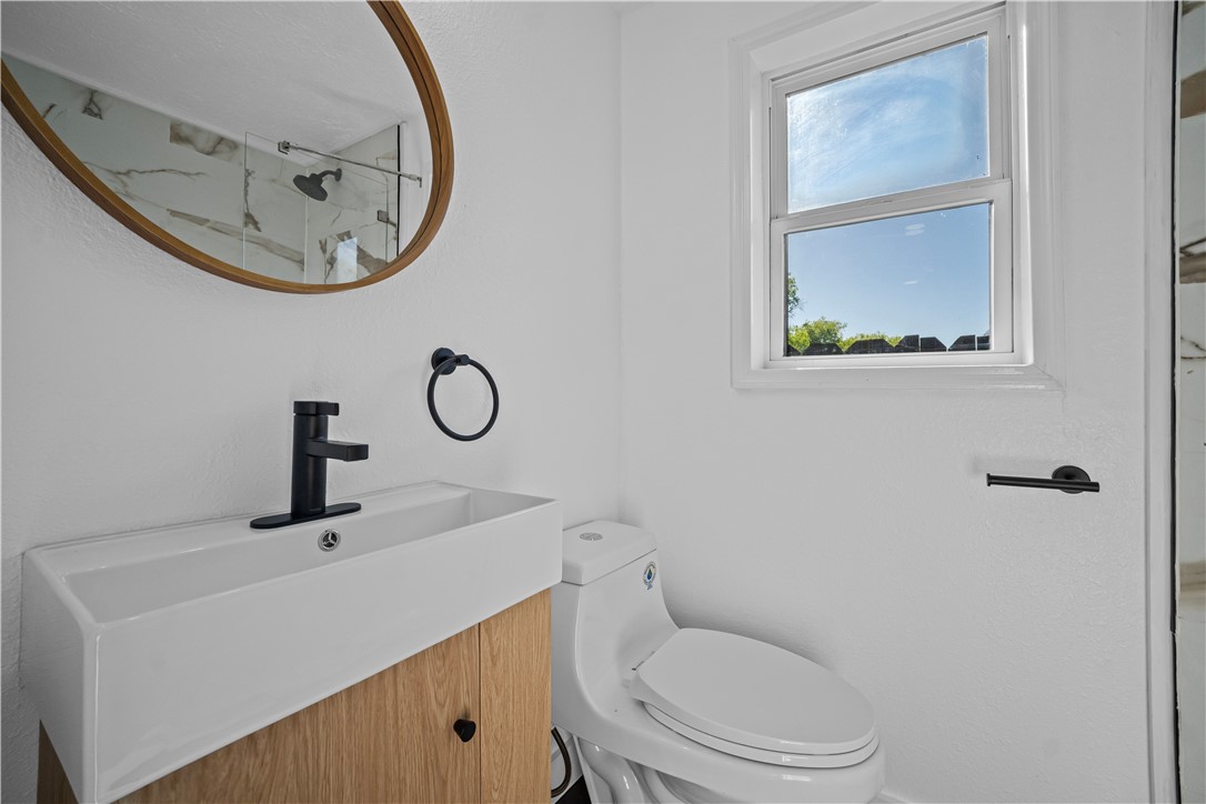 1012 East Main Street Sinton, TX 78387 - Photo 23 of 34 a bathroom with a toilet a sink and mirror